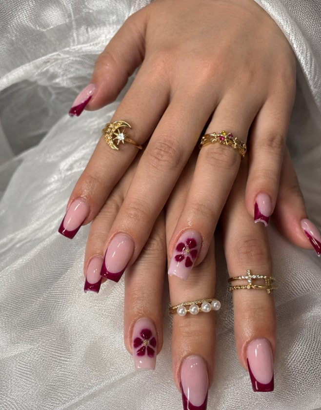 Manos con manicura francesa en granate y flores pintadas a mano